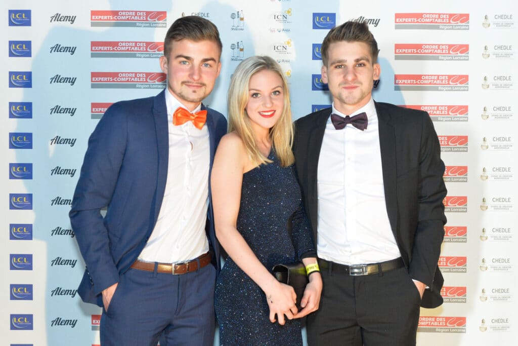 Trois invités devant le fond aux logos partenaires, ICN Business School