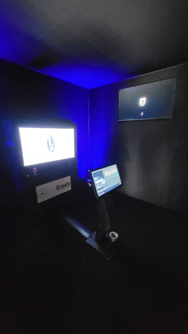 Box hologramme affichant l'étoile Mercedes et borne tactile sur pied, dans la cabine noire de la Black Box