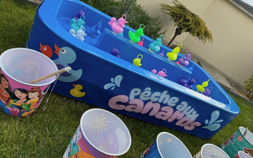 Bassin de pêche aux canards avec canards, cannes et seaux colorés