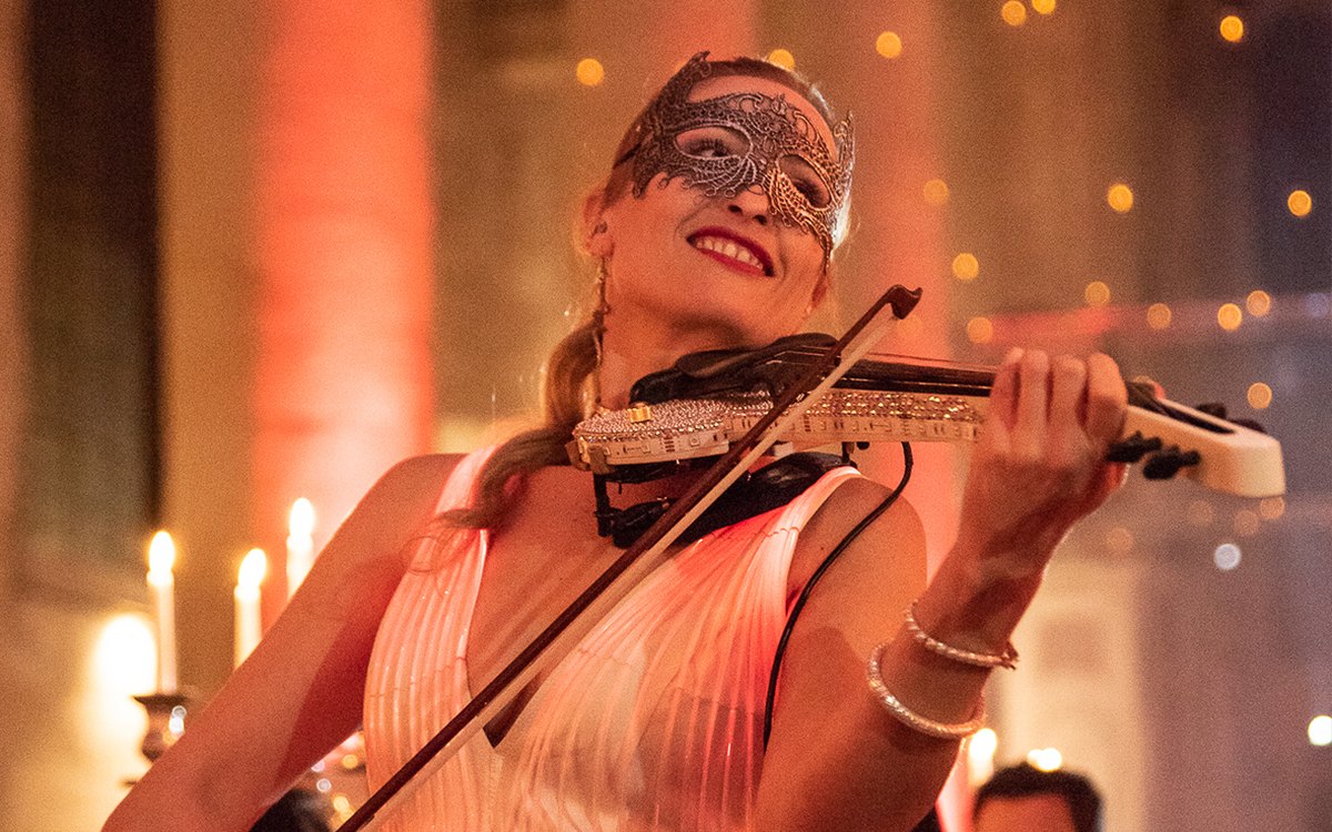 Violoniste électrique masquée jouant en live parmi les invités, abbaye des Prémontrés