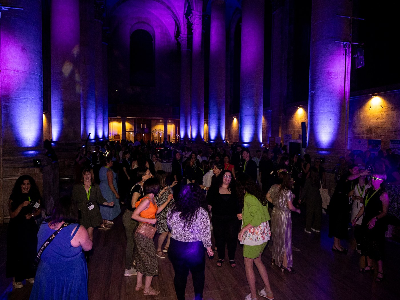 Colonnes de l’abbaye des Prémontrés éclairées en violet par les projecteurs LORENTS au-dessus de la piste de danse d’une soirée d’entreprise