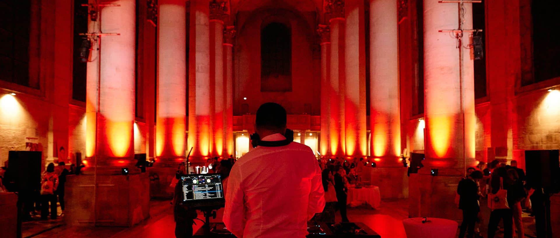 DJ LORENTS aux platines dans la nef de l'abbaye des Prémontrés éclairée en rouge