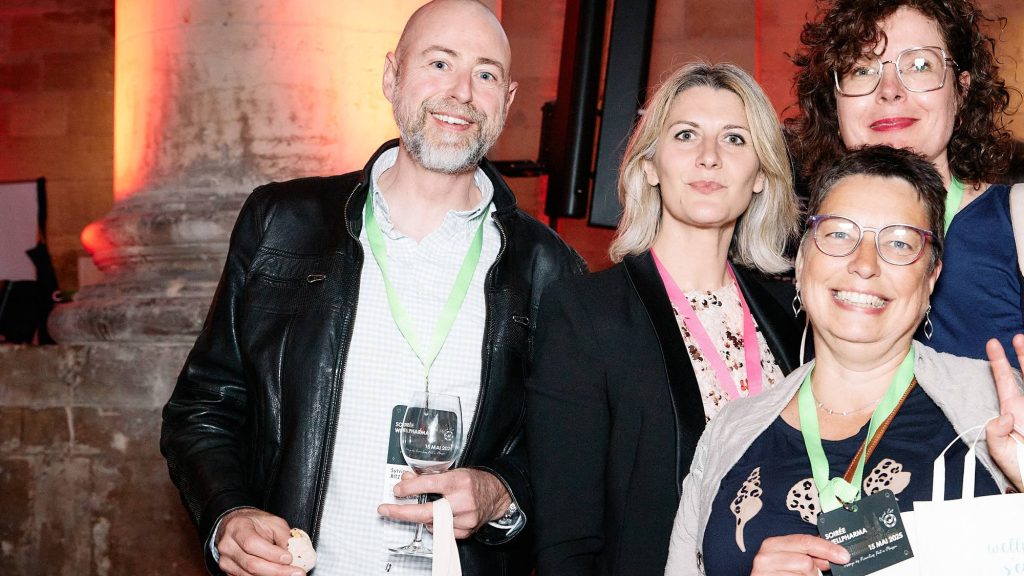 Un groupe d’invités rit et lève la main pendant le cocktail d’une convention