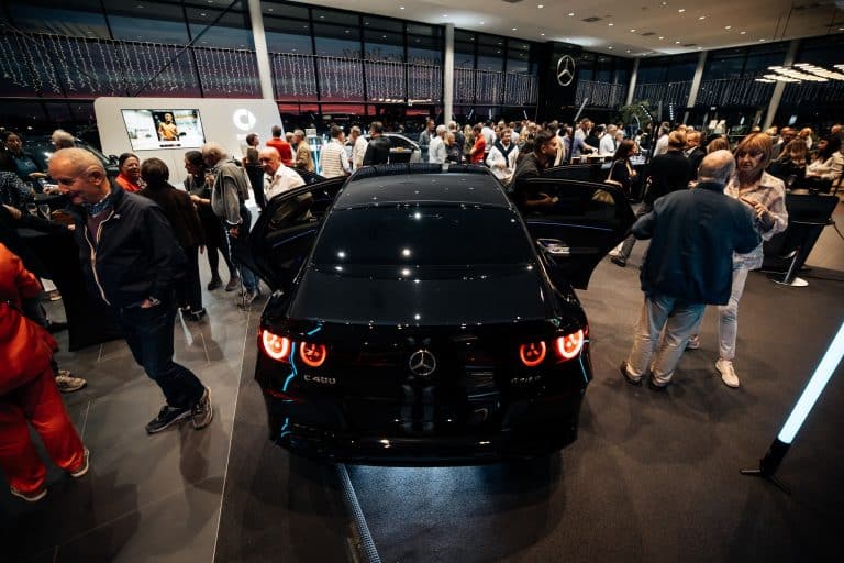 Showroom Mercedes-Benz Kroely de Metz rempli d'invités, Mercedes noire vue de l'arrière et tube LED vertical à droite