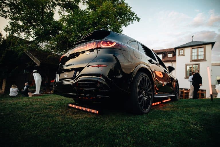 Arrière d'un Mercedes GLC noir sur la pelouse, barres LED orangées posées sous le pare-chocs et le long du bas de caisse