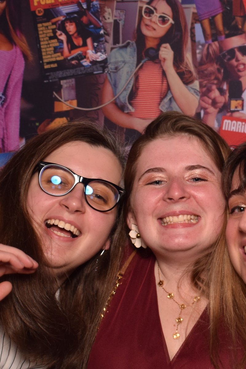 Deux invitées éclatent de rire devant le photocall