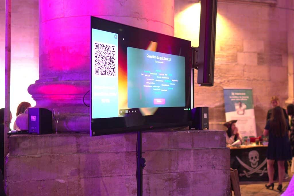 Écran du quiz digital installé au milieu du salon, question et QR code pour jouer depuis son téléphone