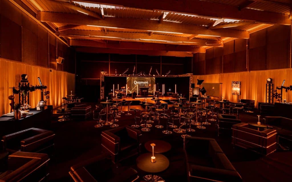 Salle mise en ambre, mobilier lounge et scène, séminaire Quipment 2024, agence LORENTS