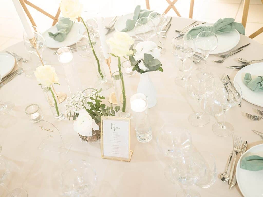 Détail d'une table de réception, roses blanches et menu, salle Mirabelle