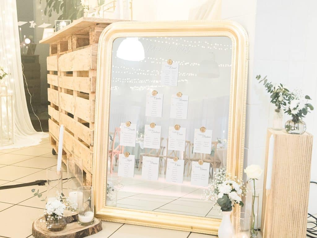 Plan de table présenté sur un grand miroir doré à l'entrée de la salle Mirabelle