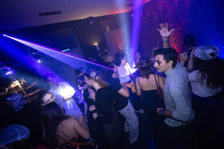 Faisceaux laser violets au-dessus des étudiants déguisés sur la piste du Mc Fly, soirée Halloween d’ESN Nancy éclairée par LORENTS