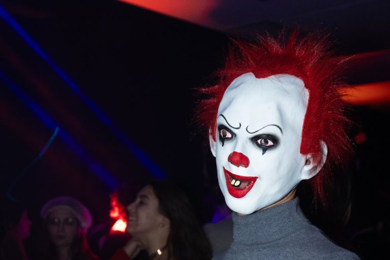 Invité en masque de clown aux cheveux rouges pendant la soirée Halloween d’ESN Nancy au Mc Fly, lumière LORENTS