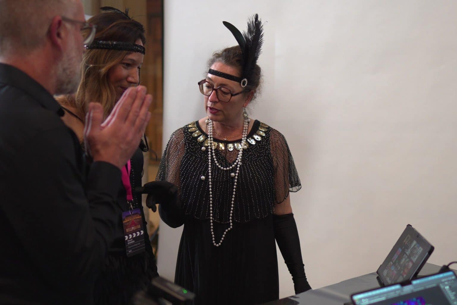 Le photographe LORENTS dirige la pose d’une invitée en costume années 20 au stand photo
