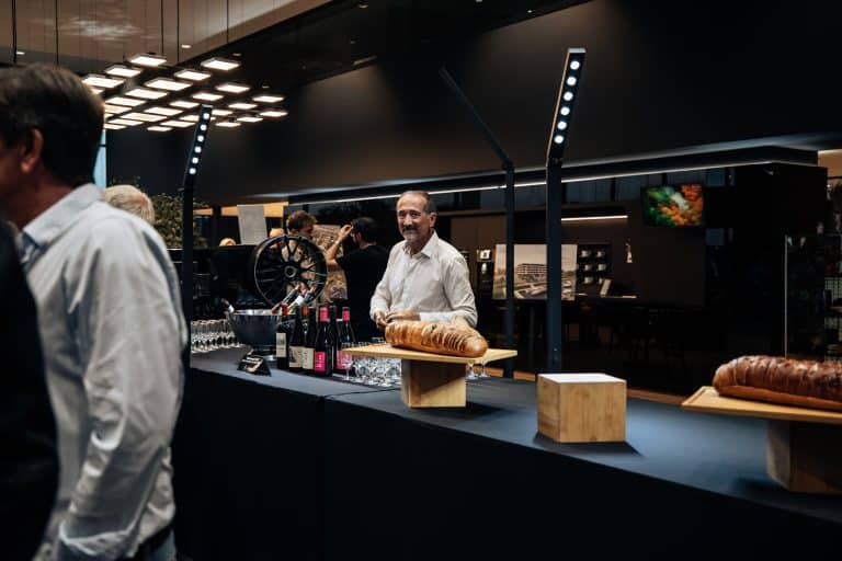 Deux tubes LED verticaux dressés derrière le buffet du cocktail, serveur et bouteilles, showroom Mercedes-Benz Kroely